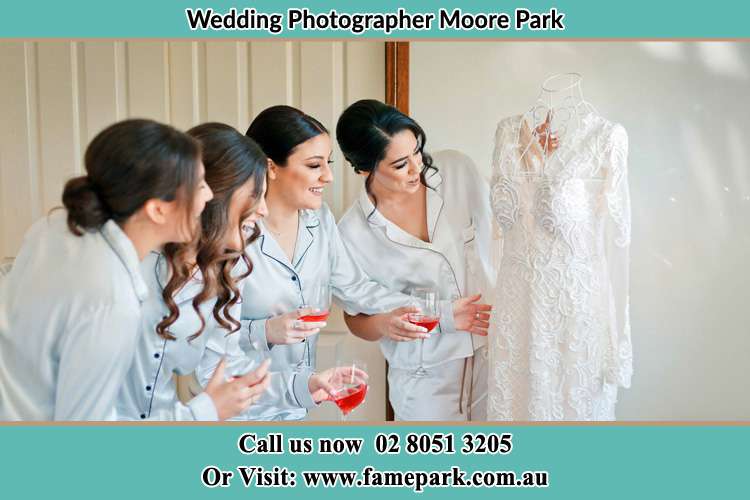 Bride looking at the wedding gown with her bride's maids Moore Park NSW 2021