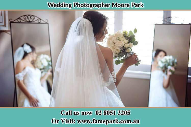 Bride looking at the mirror with bouquet of flowers Moore Park NSW 2021