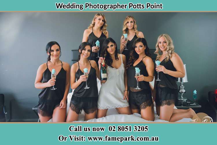 Bride and bride's maids holding wine in the bed Potts Point NSW 2011