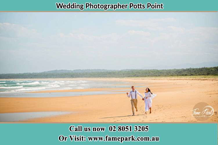 Bride and Groom running at the beach Potts Point NSW 2011