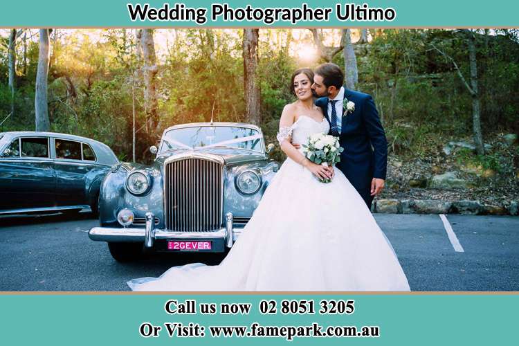 The Groom Kiss the Bride beside the bridal car Ultimo